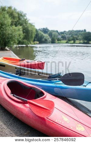 Three Kayaks On The Shore Of A Small Lake In Summer In Wimbledon Park In London