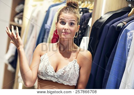 Beautiful woman thinking what to dress in walk-in closet
