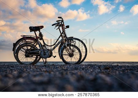 Bicycles In Love On Beach, During The Sunset