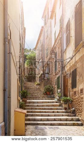 Narrow Steep Alley With Steps In Historic Spanish Village On Island Of Mallorca