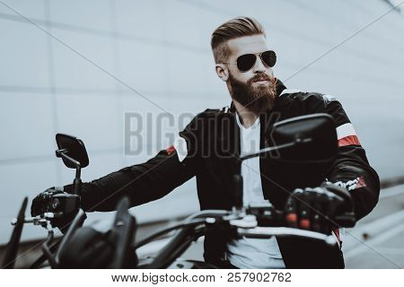 Man In Leather Jacket Is Sitting On Motorcycle. Going For Ride. Fashion Rider. Confident Stare. Spee