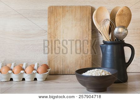 Crockery, Clayware, Dark Utensils And Other Different Stuff On Wooden Tabletop. Kitchen Still Life A