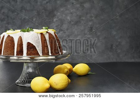 Whole Lemon Cream Cheese Bundt Cake With Slices Of Fresh Lemons And Mint On Top. Extreme Shallow Dep