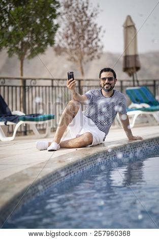 Middle Aged Arab Man Enjoying His Summer Holiday By A Pool