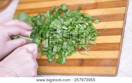 Woman Cutting Sorrel By Knife On The Wooden Cooking Desk