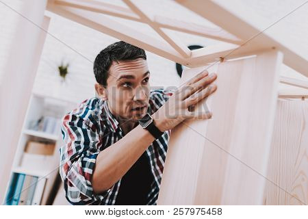 Young Man Assembling Wooden Bookshelf At Home. Wooden Bookcase. Selfmade Furniture. Man And Hobby. W