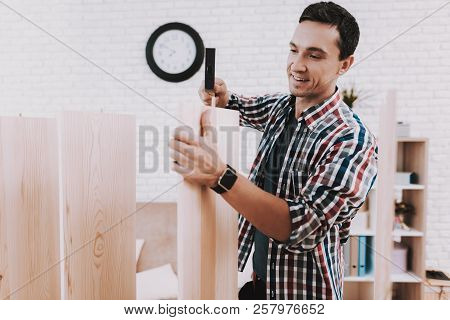 Young Man Assembling Wooden Bookshelf At Home. Wooden Bookcase. Selfmade Furniture. Man And Hobby. W