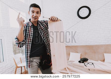 Young Man Assembling Wooden Bookshelf At Home. Wooden Bookcase. Selfmade Furniture. Man And Hobby. W