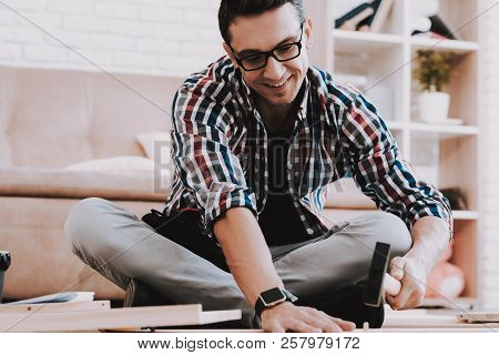 Young Man Assembling Wooden Bookshelf At Home. Wooden Bookcase. Selfmade Furniture. Man And Hobby. W