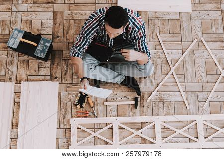 Young Man Assembling Wooden Bookshelf At Home. Wooden Bookcase. Selfmade Furniture. Man And Hobby. W
