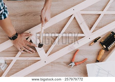 Young Man Assembling Wooden Bookshelf At Home. Wooden Bookcase. Selfmade Furniture. Man And Hobby. W