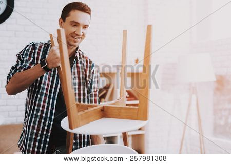 Young Man Assembling Coffee Table And Stools. Furniture Fittings. Engineer With Tool. Young Man At H