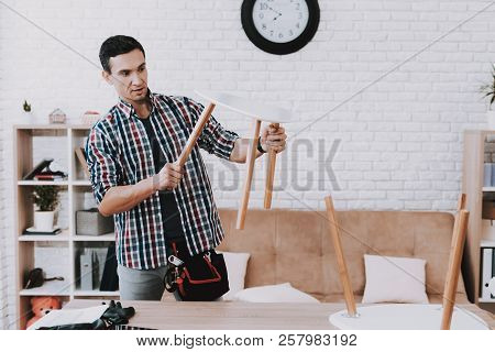 Young Man Assembling Coffee Table And Stools. Furniture Fittings. Engineer With Tool. Young Man At H