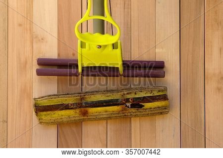 Old Broken Squeezed Squeegee With A Dirty Soft Sponge. A Mop On The Telescopic Handle That Can Be Sq