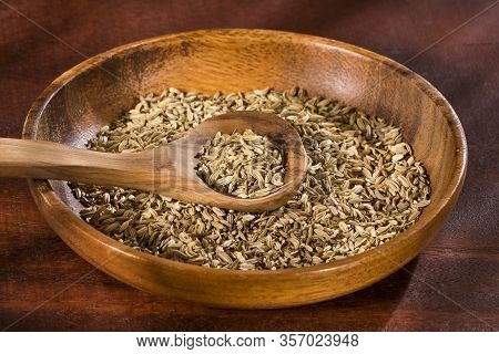 Dried Fennel Seeds In A Wooden Bowl With Wooden Spoon - Foeniculum Vulgare