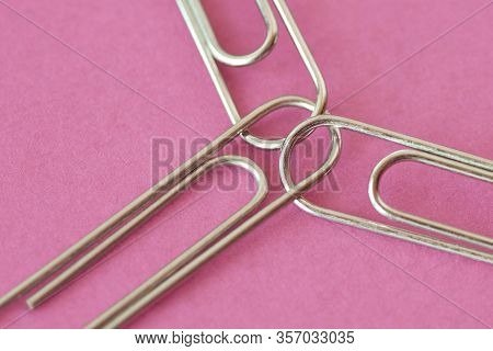 Three Joined Paper Clips On Pink Background - Concept Of Unity And Solidairity Between Women