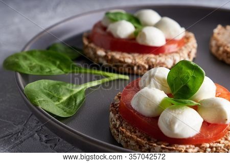 Toasts With Mozzarella, Tomatoes And Spinach In A Gray Plate