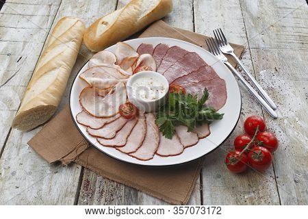 Cold Smoked Meat Plate With Pork Chops, Prosciutto, Salami And Bread Sticks On White Wooden Backgrou
