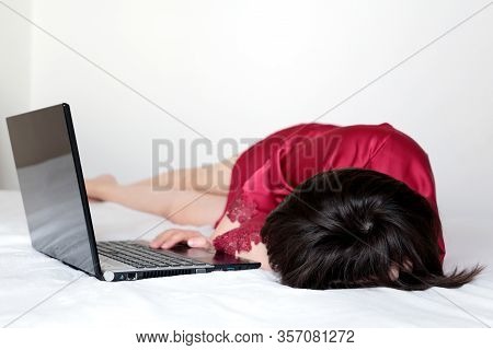 Woman Sleeping Near The Laptop At Home, Sick Girl In Red Nightie Lying On A Bed. Concept Of Tired Af