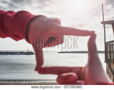 Close Up Girl Hands Make Frame Gesture. Afternoon Sun Above Stony Pier Of Sea.  Sunny Spring Day Wit