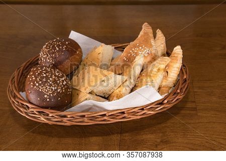 Natural Cereal Rural Bread With Spices, Herbs And Sesame Seeds In A Wicker Basket. Useful Apitizer B