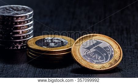 One Real Coins Isolated On Black Background. Money From Brazil. Brazil Economy Or Financial Crisis C