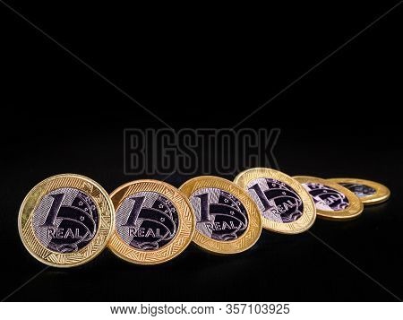 Images Of One Real Coins, Money From Brazil On Isolated Black Background. Falling Real Of The Brazil