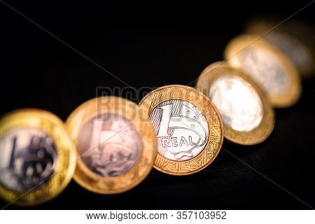 Images Of One Real Coins, Money From Brazil On Isolated Black Background. Falling Real Of The Brazil