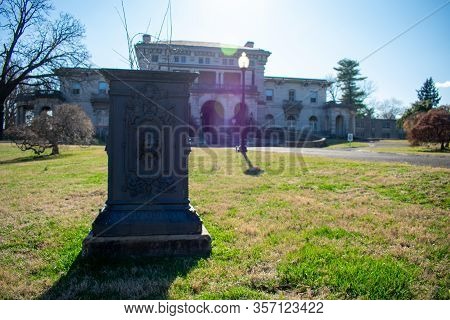 A Dark Colored Ornamenta Flower Planter Out Front Of Elkins Park On A Bright Spring Day