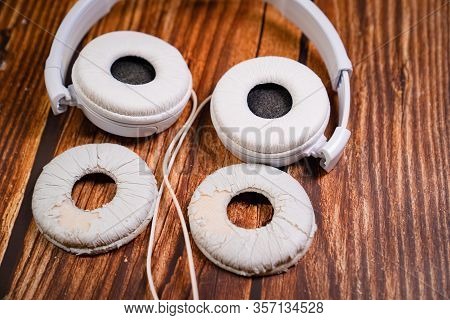 Need A Replacement Embouchures On Old White Earbud. Repair Accessories.wooden Background