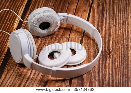 Need A Replacement Embouchures On Old White Earbud. Repair Accessories.wooden Background