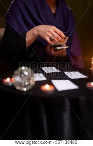 12.02.20. Moscow, Russia. Fortuneteller divines on cards at table with candles