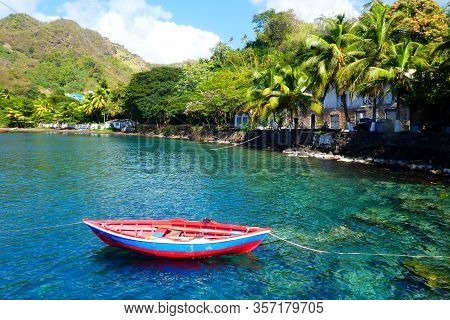 Lonely boat floats on clear water in the caribbean