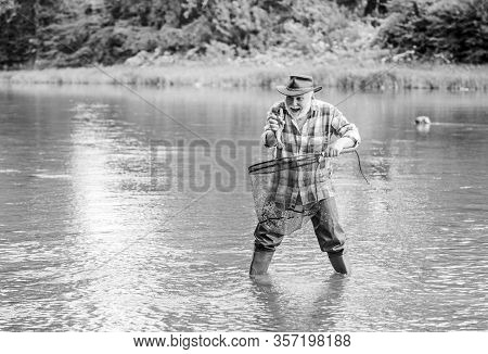 Fisherman Fishing Equipment. Hobby Sport Activity. Fisherman Alone Stand In River Water. Man Senior 