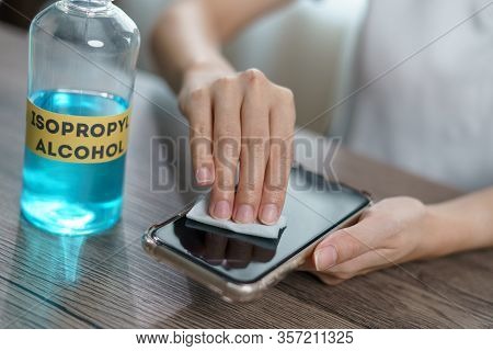 Hand Pouring Ethyl Alcohol From Bottle  Into A Cotton Piece For Clean Mobile Phone, Corona Virus Or 