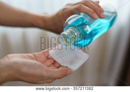 Pouring Ethyl Alcohol From Bottle  Into A Cotton Piece For Corona Virus Or Covid-19 Protection.