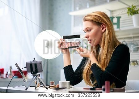 Vlogger Female Showing Eye Shadow Palette. Beauty Blogger Woman Filming Daily Make-up Routine Tutori