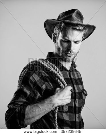 Western Life. Man Cowboy Beige Background. Man Wearing Hat Hold Rope. Ranch Occupations. Lasso Tool 