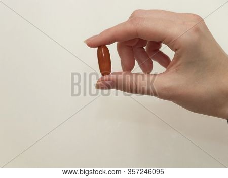 Female Hand Holds A Tablet, Capsule In Hands. On White Background. Pharmaceuticals. Allopathic Medic