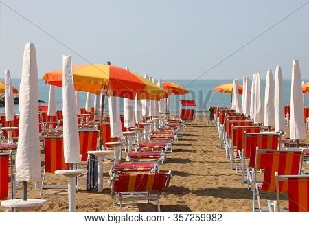 Rows Of Deckchairs And Parasols On The Private Beach Of A Tourist Village Without People