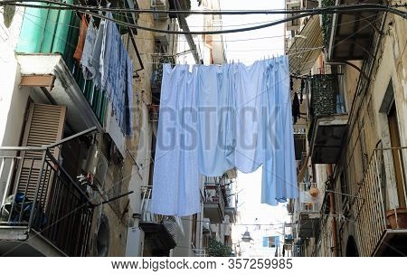 White Clothes Hung Out To Dry Between The Terraces Of Two Houses