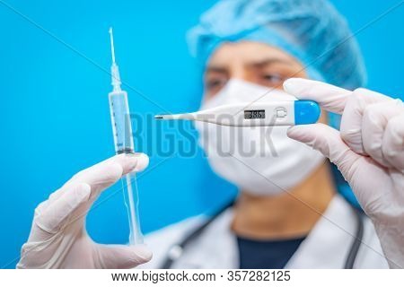 Medical Laboratory Syringe And High Temperature Thermometer In Hands Of Young Virologist Female Doct