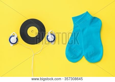 Blue Sports Socks, Vintage Headphones, And A Vinyl Disc On A Yellow Background. The Concept Of Music