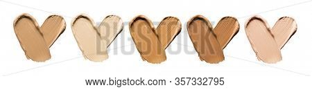 Foundation smears palette close-up. Heart shaped make-up smudge, smear. Cosmetic liquid bb cream beige color smudges, strokes. Colorful Liquid Make up concealer isolated on white background. 