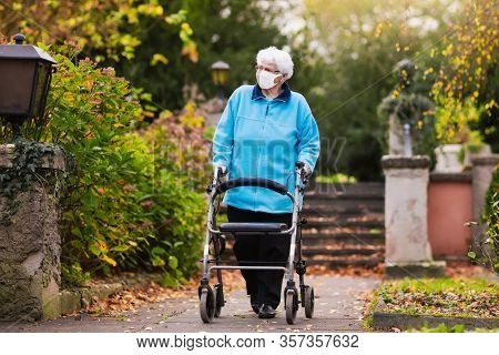 Senior Handicapped Lady Wearing Face Mask With A Walking Disability At Coronavirus Outbreak
