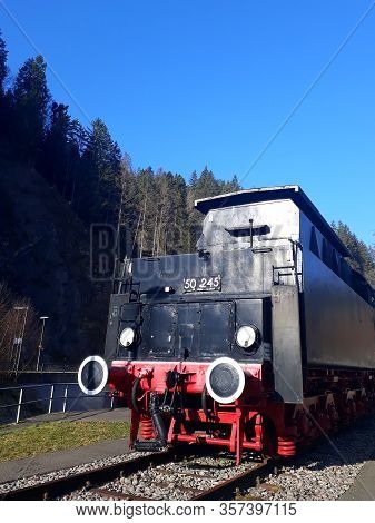 An old locomotive on a railroad with blue sky