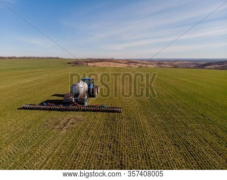Tractor Applying Liquid Mineral Fertilizers To The Soil On Winter Wheat