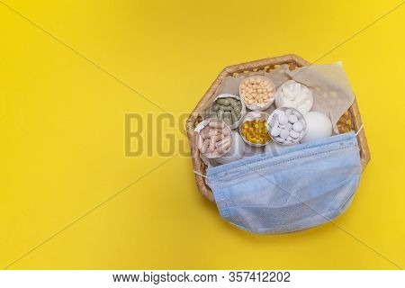 Eggs In The Wicker Basket On The Yellow Background. Madical Mask On The Basket. Copy Space. Place Fo