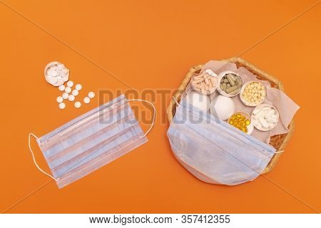 Eggs In The Wicker Basket On The Orange Background. Madical Mask On The Basket. Copy Space. Place Fo