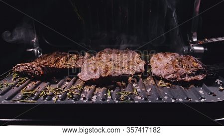 Delicious Juicy Meat Steak Cooking On Grill. Aged Prime Rare Roast Grilling Marble Beef. Electric Ro